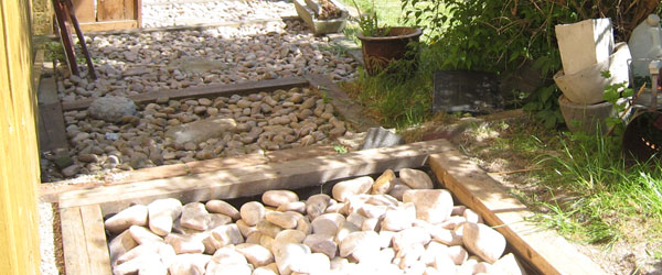 Regnvandsopsamling i haven, faskine med sten i en træramme